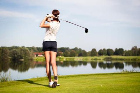 Woman playing golf in mid-swing